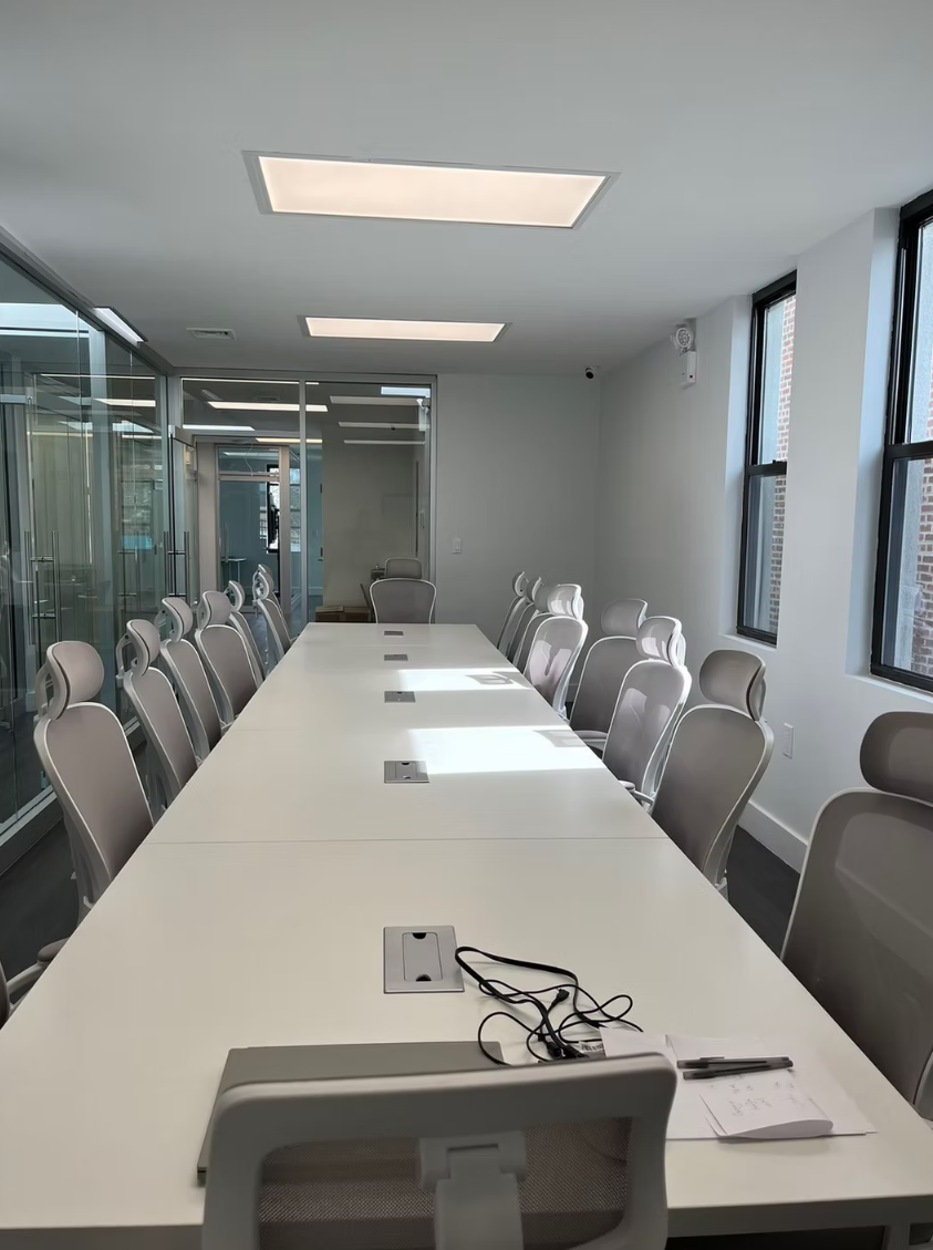 Long ToIvy meeting room with twelve ergonomic chairs and continuous white work surface