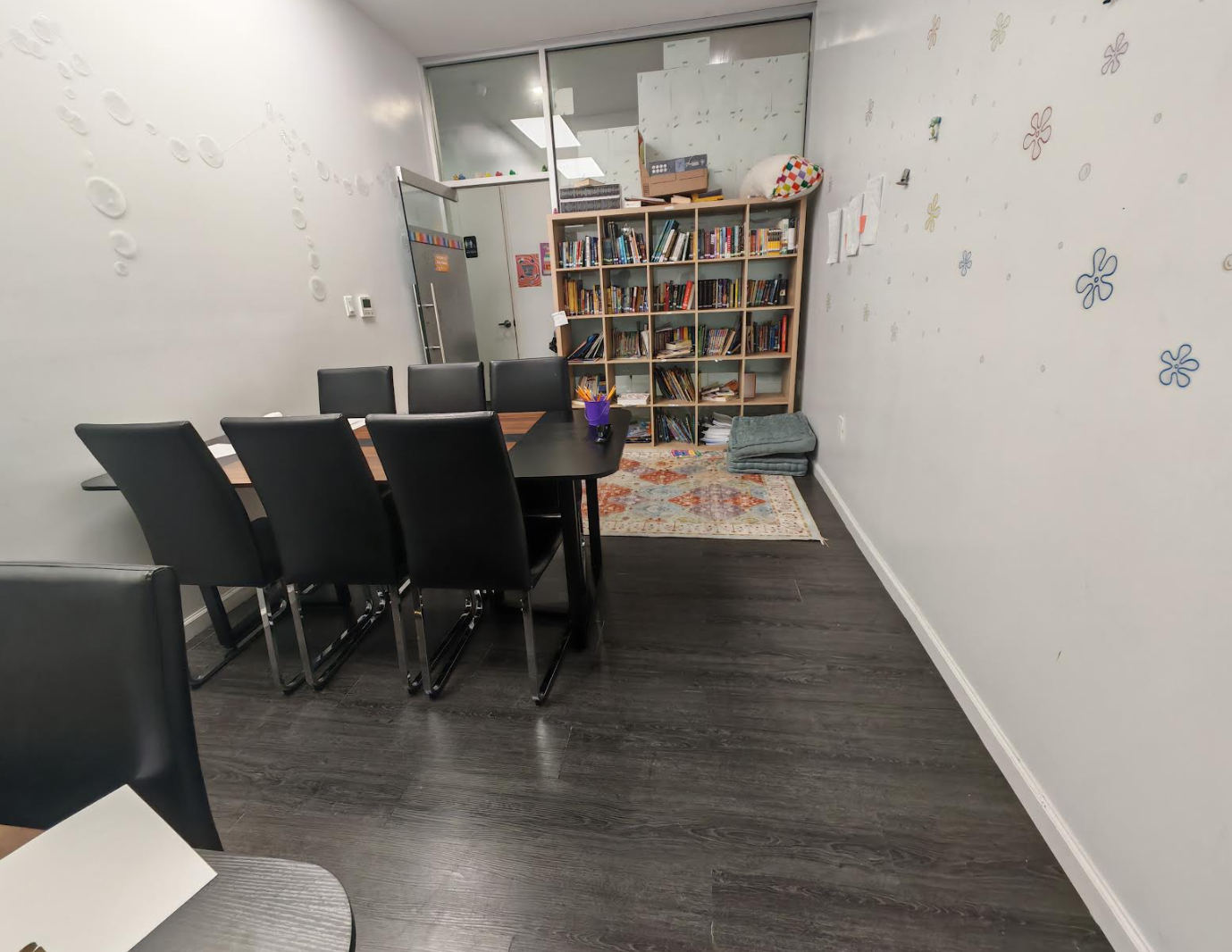 ToIvy elementary reading room with a full bookshelf of children's literature, decorated walls, area rug, and a discussion table